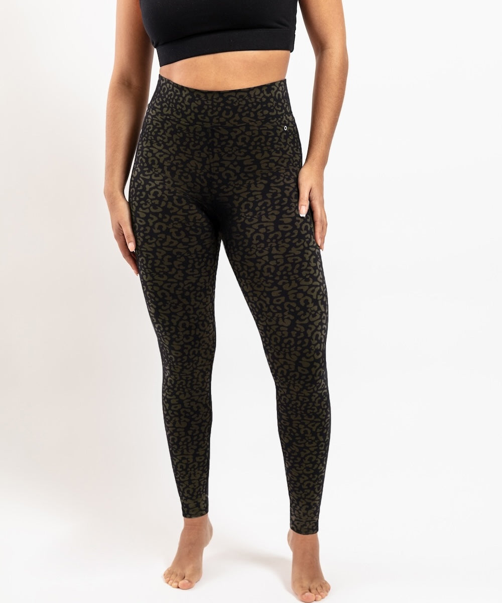 Person wearing black patterned leggings on a white background