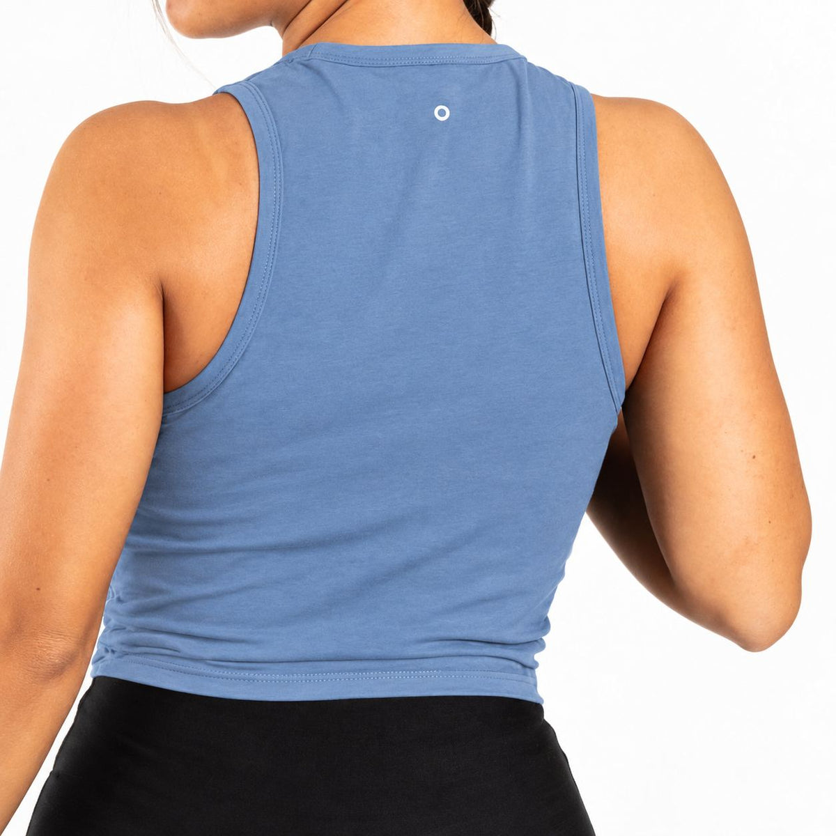 Back view of a woman wearing a sleeveless blue Organic Cotton Tank Top with built in bra and black bottoms against a plain white background.