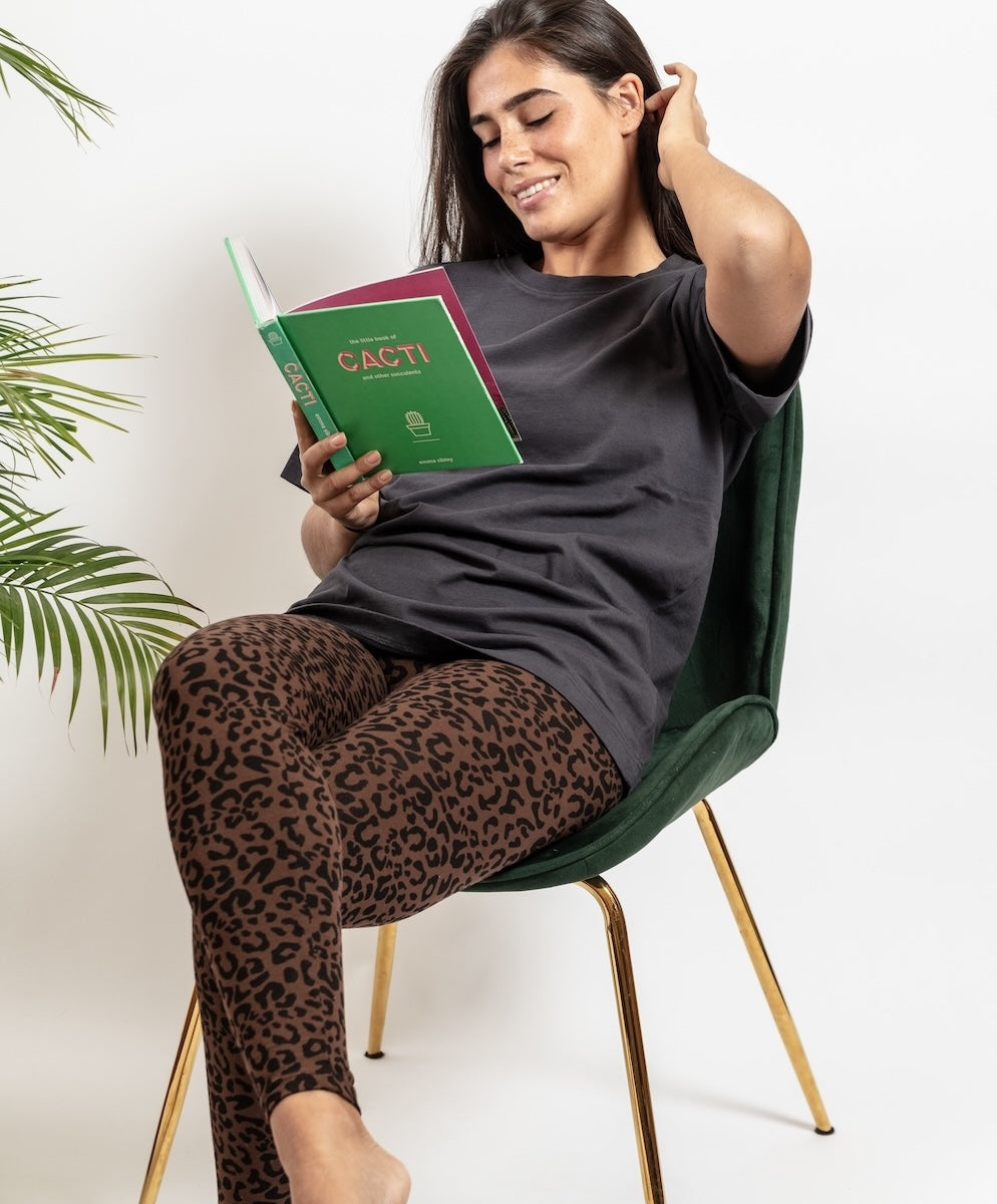 Woman sitting on a green chair holding a book